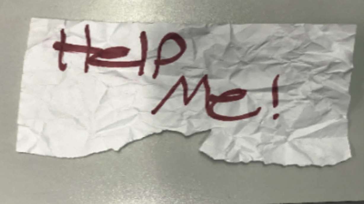 A photo shows the "Help Me!" sign used by a 13-year-old girl kidnapped in Texas. The girl was rescued in Southern California on July 9 when passersby saw her hold up the sign in a parked car, police said.