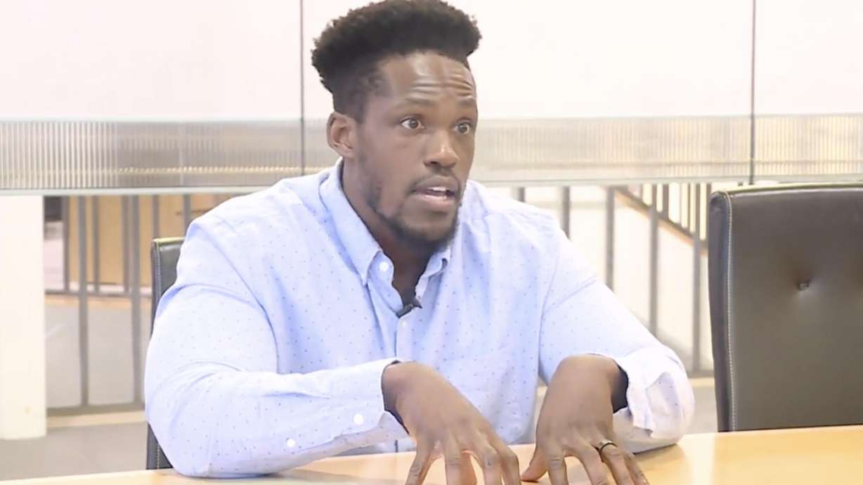 Utah State University alum Gregory Noel, right, talks to KSL-TV in March about a lawsuit he filed over a caricature allegedly drawn by a professor and displayed in view of his classmates. Noel has settled a lawsuit against the university for $45,000.