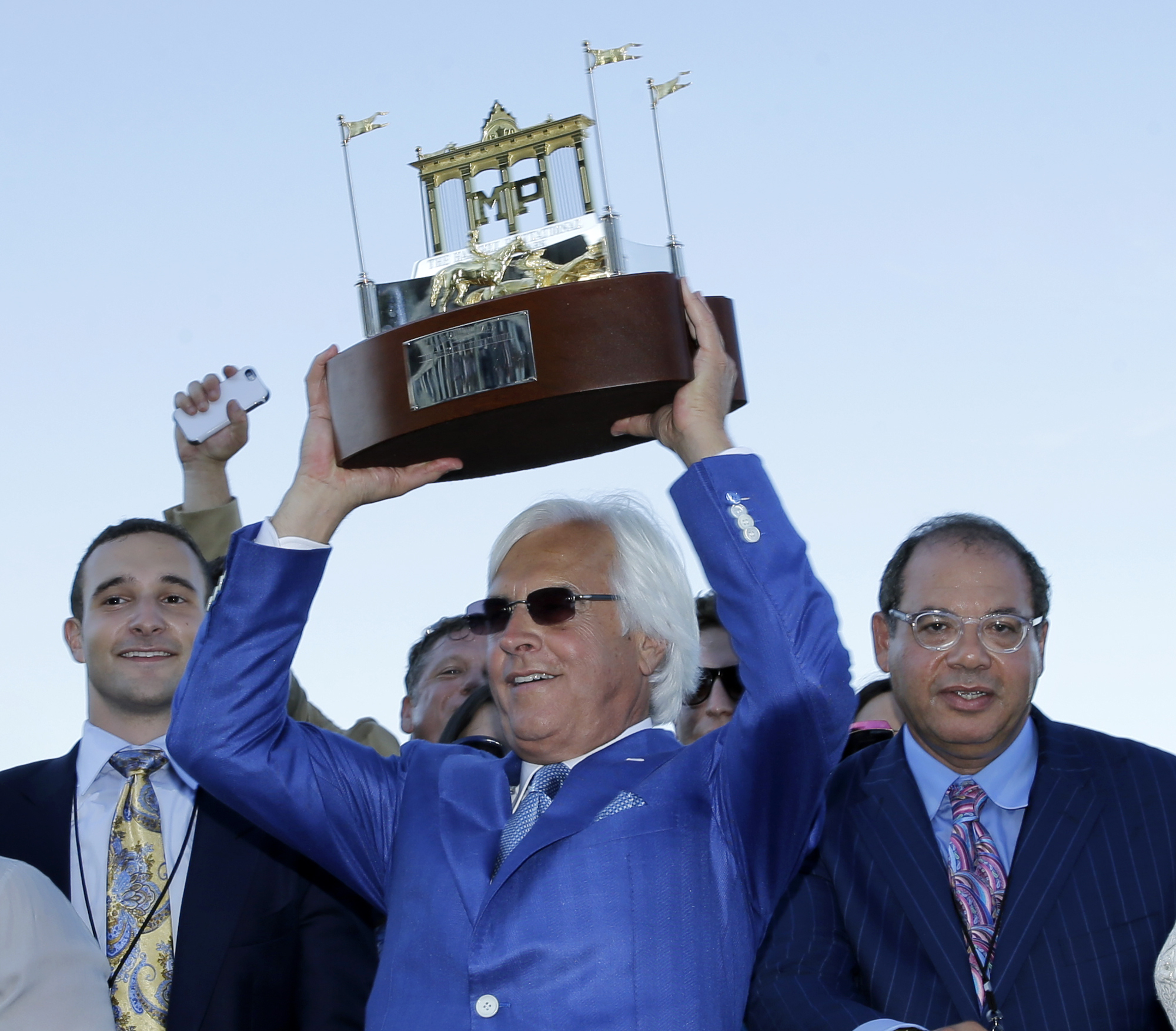 FILE - Triple Crown winner American Pharoah's trainer Bob Baffert, center, owner Ahmed Zayat, right, and his son Justin Zayat, left, celebrate with the winner's trophy after American Pharoah won the Haskell Invitational horse race at Monmouth Park in Oceanport, N.J., Sunday, Aug. 2, 2015. Baffert will look to add another Haskell Stakes and big payday to his collection when the lightly raced Arabian Knight takes on Kentucky Derby winner Mage and six others in the $1 million showcase event of the summer meet at Monmouth Park. 