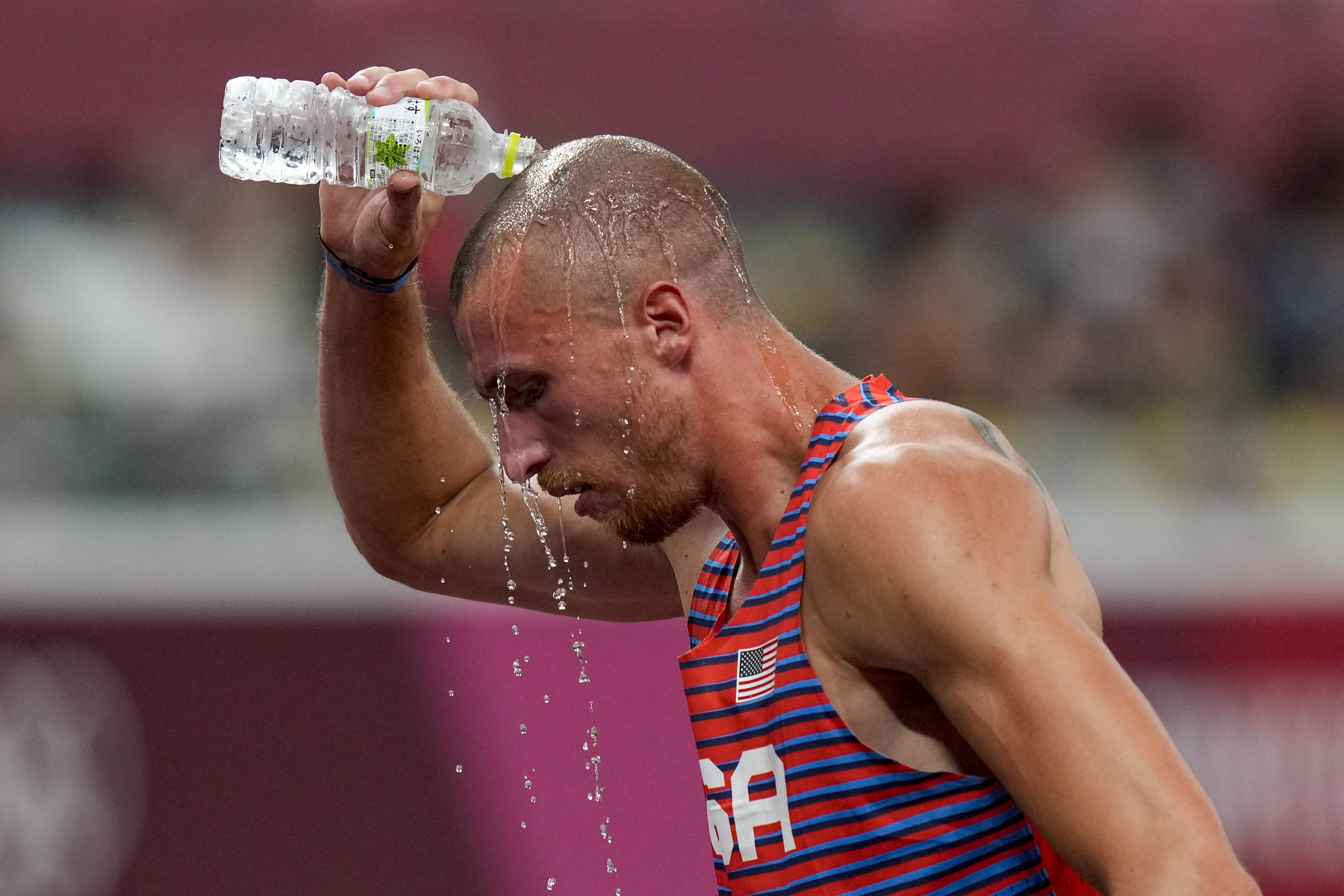 Zachery Ziemek, of the United States, cools off after a heat of the men’s decathlon 400 meters at the 2020 Summer Olympics, on Aug. 4, 2021, in Tokyo. IOC leader says impact of rising temperatures on both Summer and Winter Games being studied.