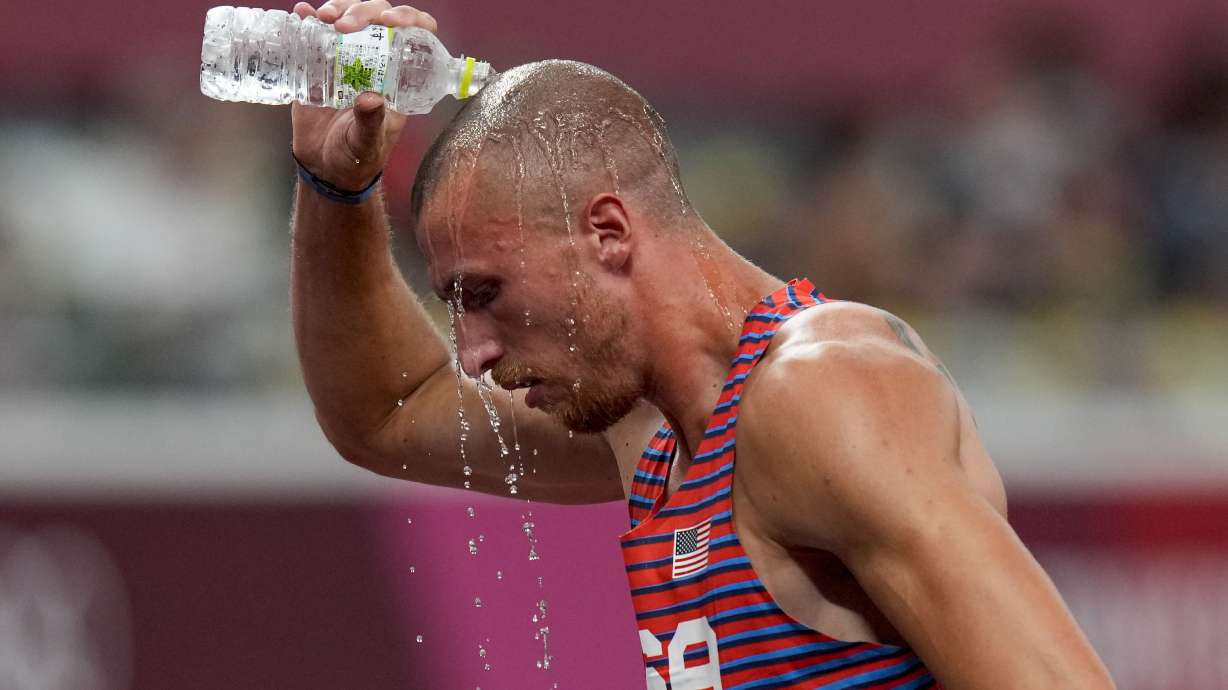 Zachery Ziemek, of the United States, cools off after a heat of the men’s decathlon 400 meters at the 2020 Summer Olympics, on Aug. 4, 2021, in Tokyo. IOC leader says impact of rising temperatures on both Summer and Winter Games being studied.