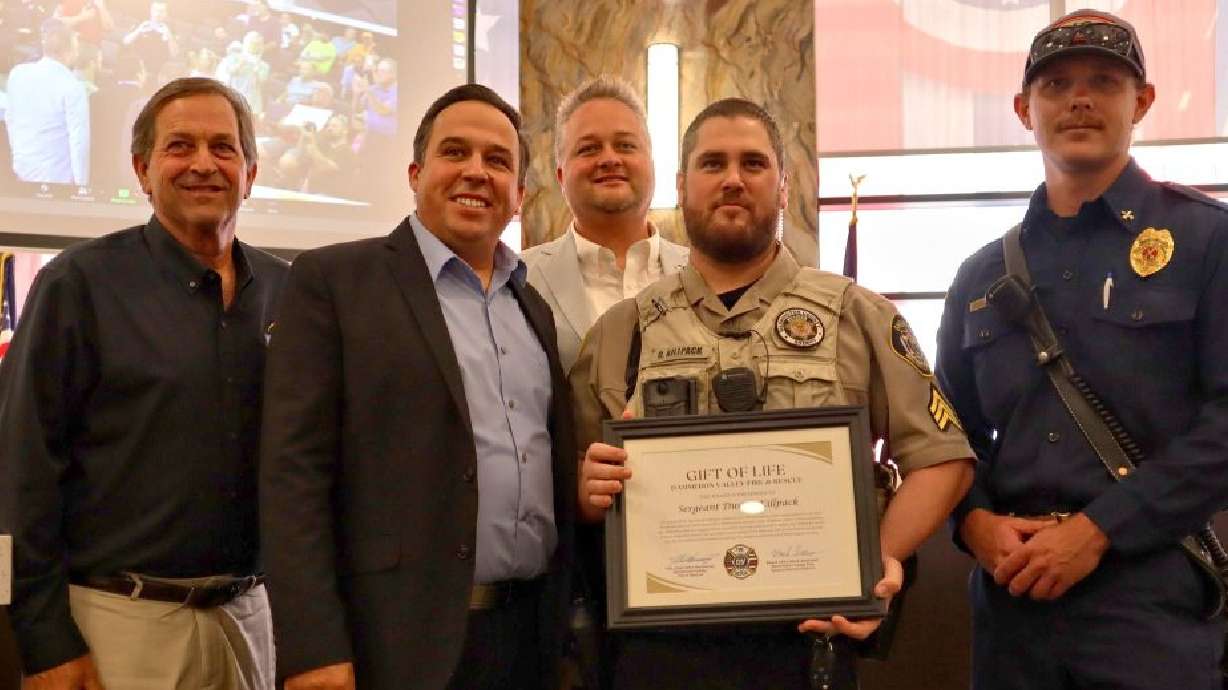 L-R: Washington County Commissioners Gil Almquist, Victor Iverson, Adam Snow (background), Washington County Sheriff’s Sgt. Dusty Killpack and Dammeron Valley Fire and Rescue Battalion Chief Ryan D’ambrosio stand for a group photo following Killpack receiving a Gift of Life Award for the part he played in saving a man from a burning car on June 9 on state Route 18, St. George, Utah, Tuesday.