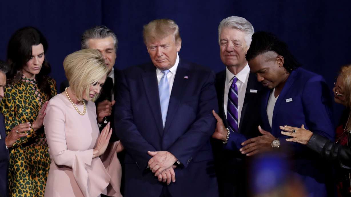 Pastor Paula White, left, and other faith leaders pray with President Donald Trump, center, during a rally for evangelical supporters at the King Jesus International Ministry church, Jan. 3, 2020, in Miami.