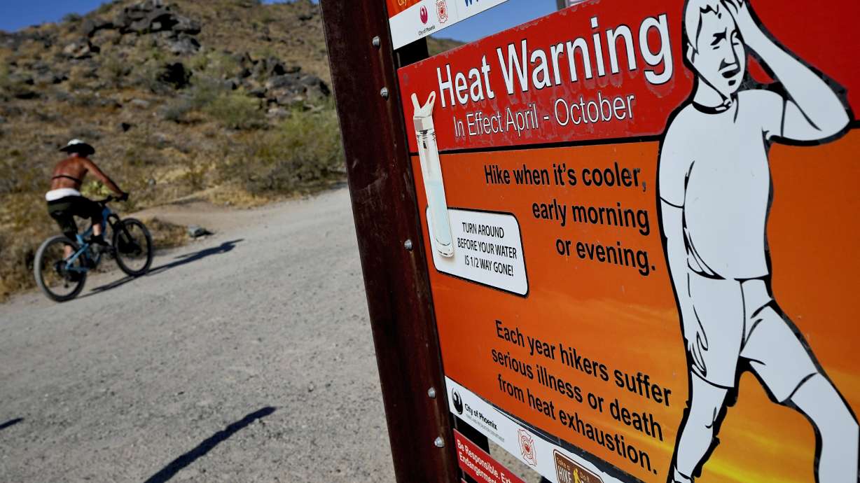 A cyclist finishes his ride early to beat high temperatures, July 10, in Phoenix. Another day's high-temperature record was broken Saturday in Salt Lake City.