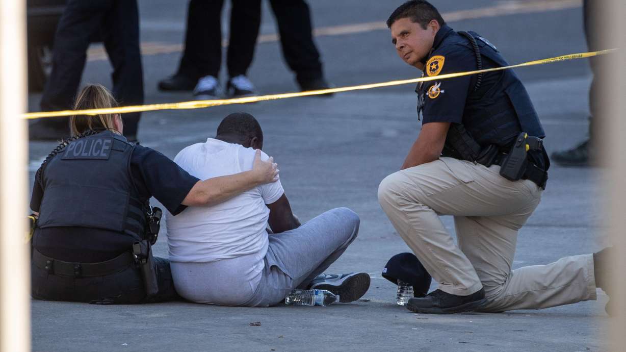 Officers console a man inside of a crime scene on 100 South, where a shooting left one dead in Salt Lake City on Sept. 3, 2022. Fraud, car break-ins and property crimes rise to the top.