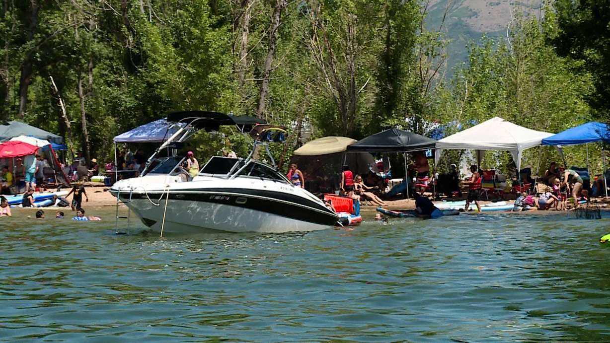 Visitors enjoy Pineview Reservoir on a hot Saturday afternoon. As more and more people try to cool off at Utah's lakes and reservoirs, more police patrol the area to keep everyone safe.