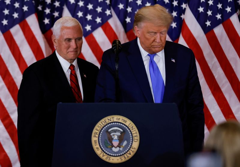 Former President Donald Trump and Vice President Mike Pence stand while making remarks about early results from the 2020 U.S. presidential election in the East Room of the White House in Washington, Nov. 4, 2020. Pence says Trump's actions around Jan. 6 attacks were reckless but not likely criminal.