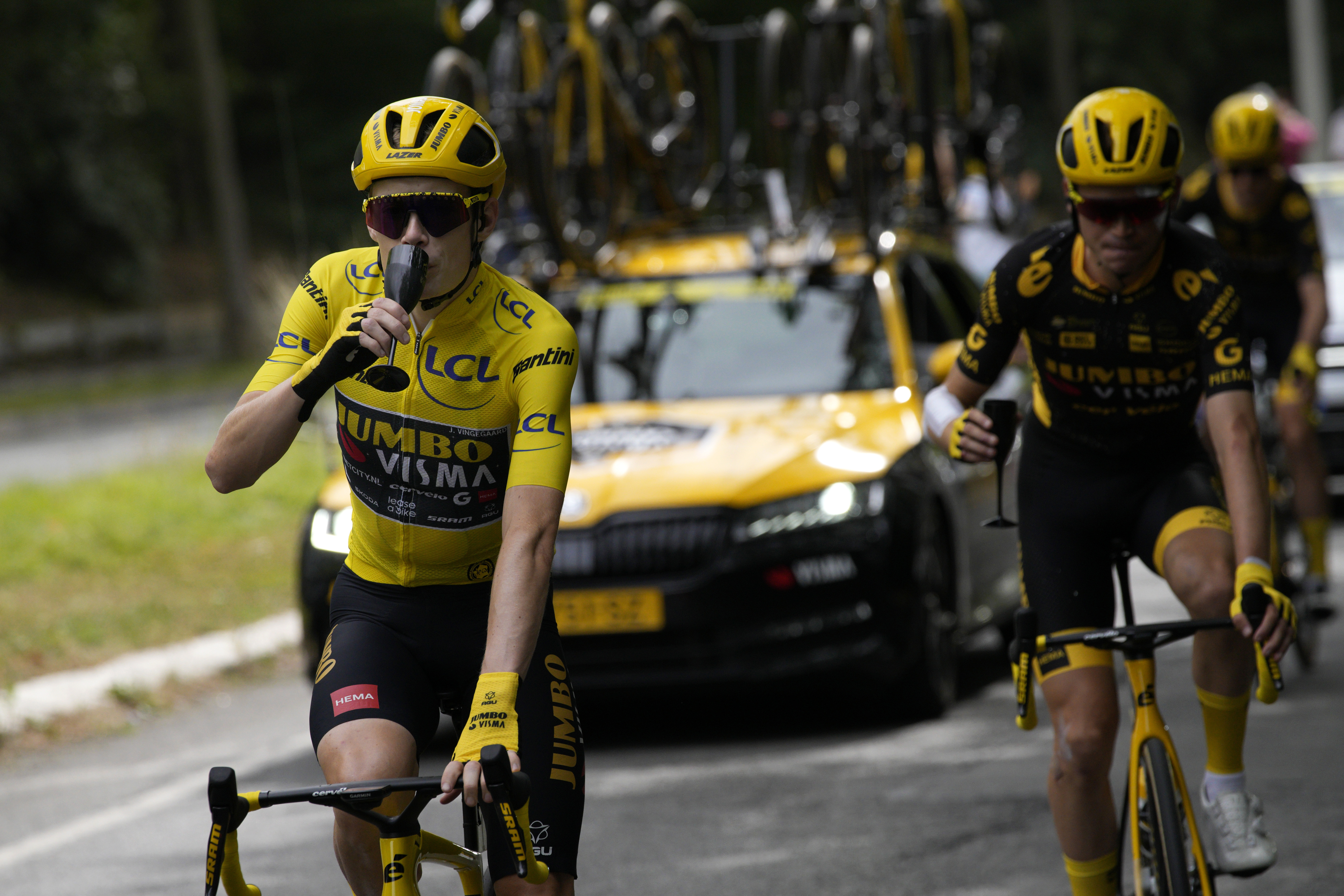 Denmark's Jonas Vingegaard, wearing the overall leader's yellow jersey, drinks champagne with teammates during the twenty-first stage of the Tour de France cycling race over 115 kilometers (71.5 miles) with start in Saint-Quentin-en-Yvelines and finish on the Champs-Elysees in Paris, France, Sunday, July 23, 2023. 