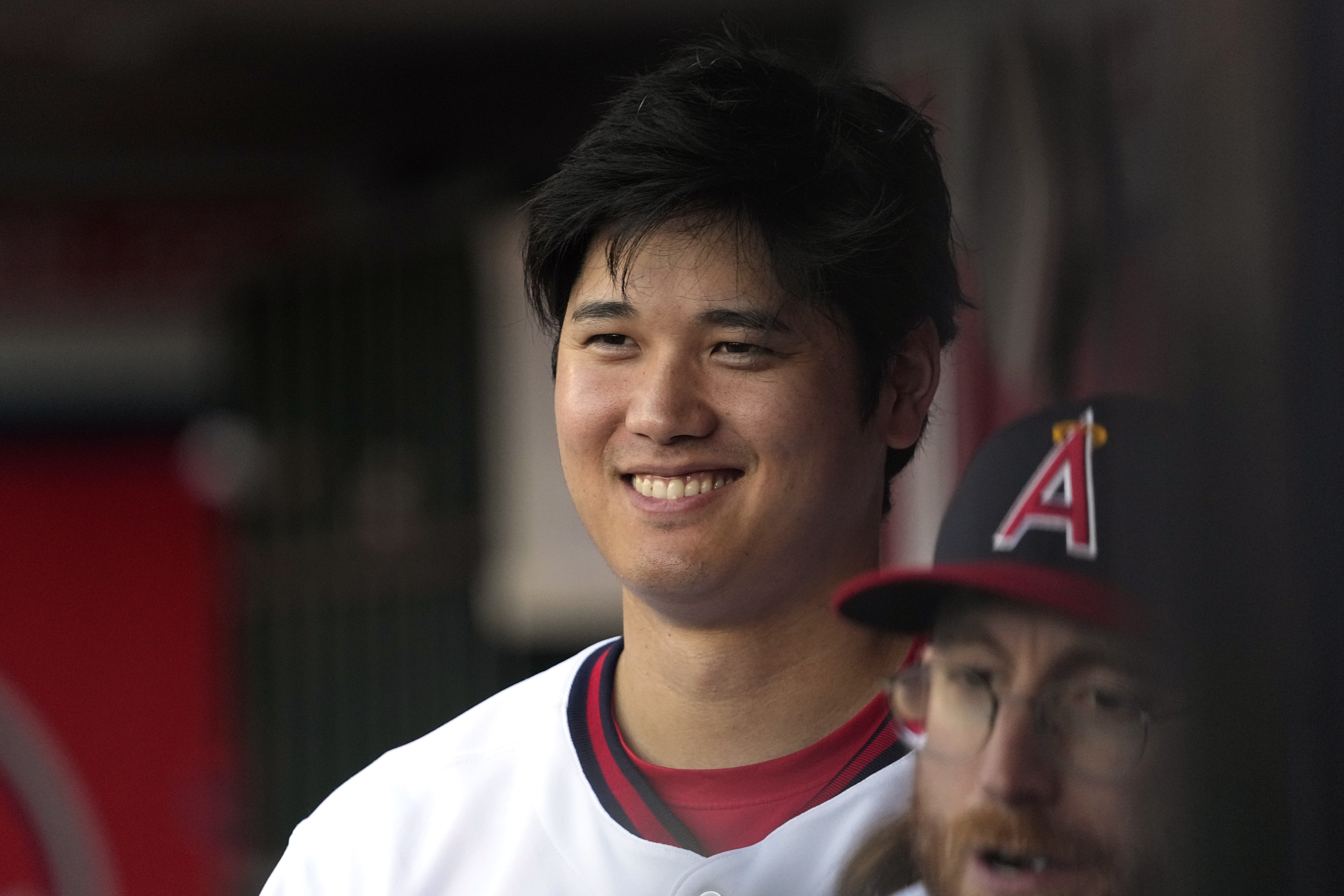 Los Angeles Angels' Shohei Ohtani smiles as he stands in the dugout prior to a baseball game against the Pittsburgh Pirates Saturday, July 22, 2023, in Anaheim, Calif.