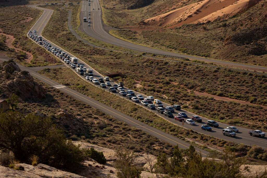 The entrance road to Arches National Park outside of Moab begins to back up with visitors on Sept. 19, 2021.