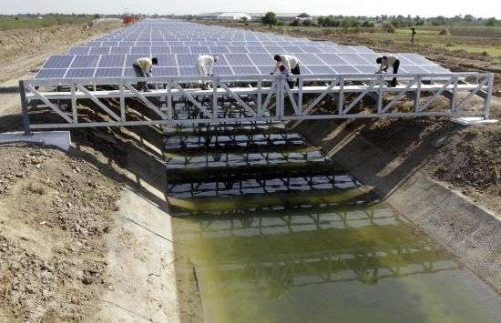 Indian workers give finishing touches to installed solar panels covering the Narmada canal at Chandrasan village, outside Ahmadabad, India, April 22, 2012. The project brings water to hundreds of thousands of villages in the dry, arid regions of western India’s Gujarat state.