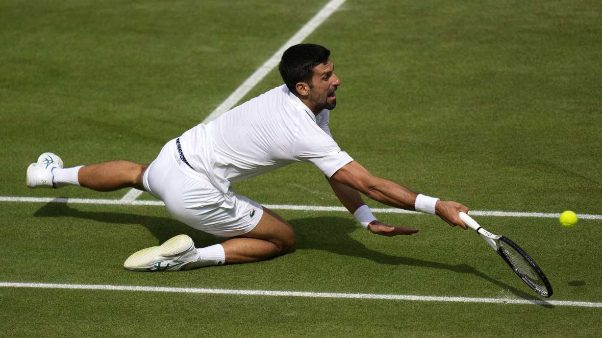 Serbia's Novak Djokovic falls as he returns to Spain's Carlos Alcaraz in the final of the men's singles on day fourteen of the Wimbledon tennis championships in London, Sunday, July 16, 2023.