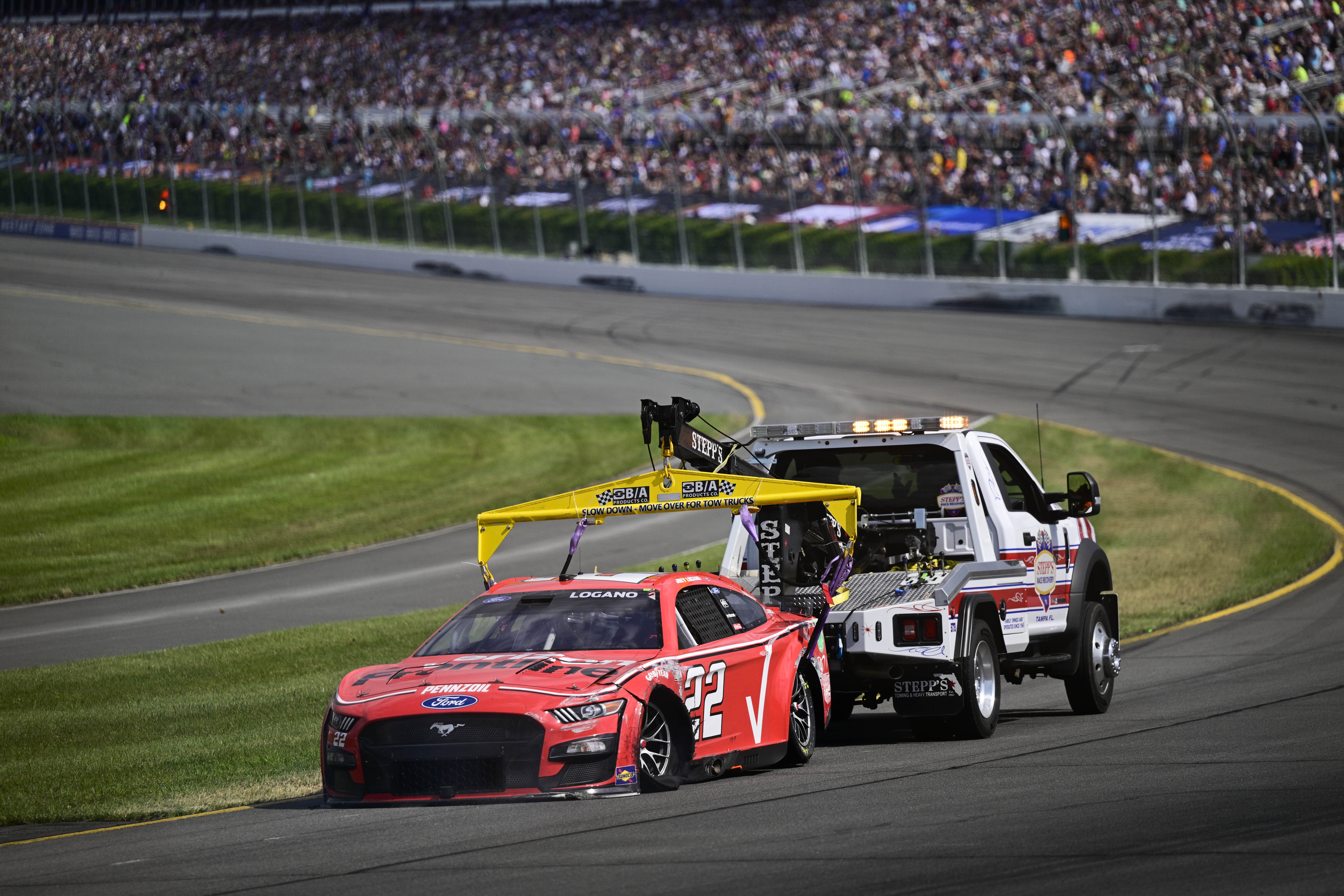 Joey Logano is towed back to the pits after an accident during a NASCAR Cup Series auto race at Pocono Raceway, Sunday, July 23, 2023, in Long Pond, Pa.