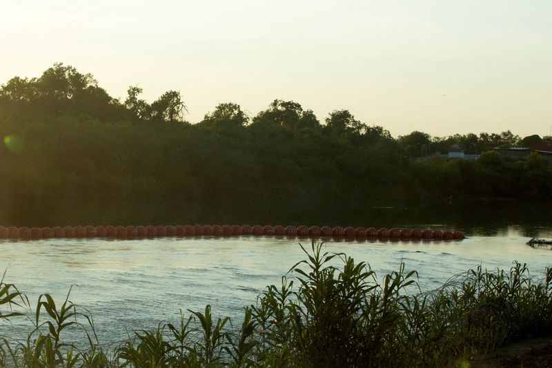 An unfinished strand of orange buoys sits in the Rio Grande River in response to migrants crossing the river, near Eagle Pass, Texas on July 11. The U.S. Justice Department on Monday sued Texas over the floating barriers.