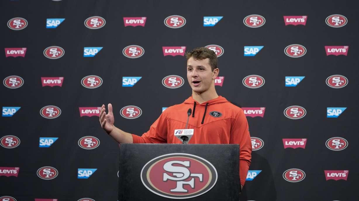 FILE - San Francisco 49ers quarterback Brock Purdy speaks to reporters after the NFL football team's practice Tuesday, May 23, 2023, in Santa Clara, Calif. Brock Purdy has been cleared to take part in training camp after undergoing surgery on his throwing elbow in the offseason. General manager John Lynch said Tuesday, July 25, 2023, that Purdy has been given the green light from doctors to practice after making good progress in his rehabilitation.