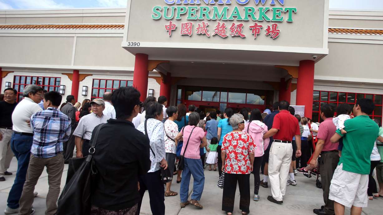 Shoppers enter the Chinatown Supermarket after a ribbon-cutting ceremony in South Salt Lake City. The franchise recently paid $525,000 in back wages, damages and penalties following a lawsuit and investigation from the U.S. Department of Labor.