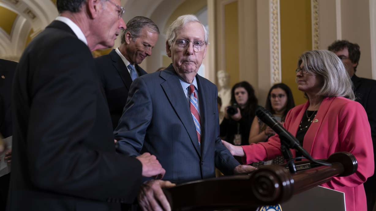 Senate Minority Leader Mitch McConnell, R-Ky., center, is helped by, from left, Sen. John Barrasso, R-Wyo., Sen. John Thune, R-S.D., and Sen. Joni Ernst, R-Iowa, after the 81-year-old GOP leader froze at the microphones in Washington on Wednesday.