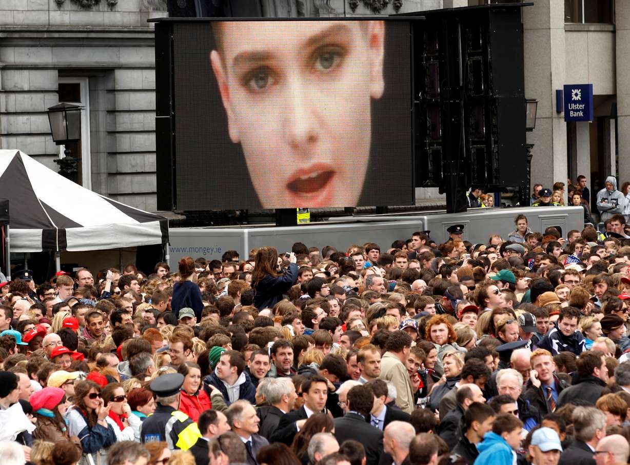 A music video of Irish singer Sinead O'Connor plays over the crowd awaiting the arrival of U.S. President Barack Obama to speak at College Green in Dublin May 23, 2011.