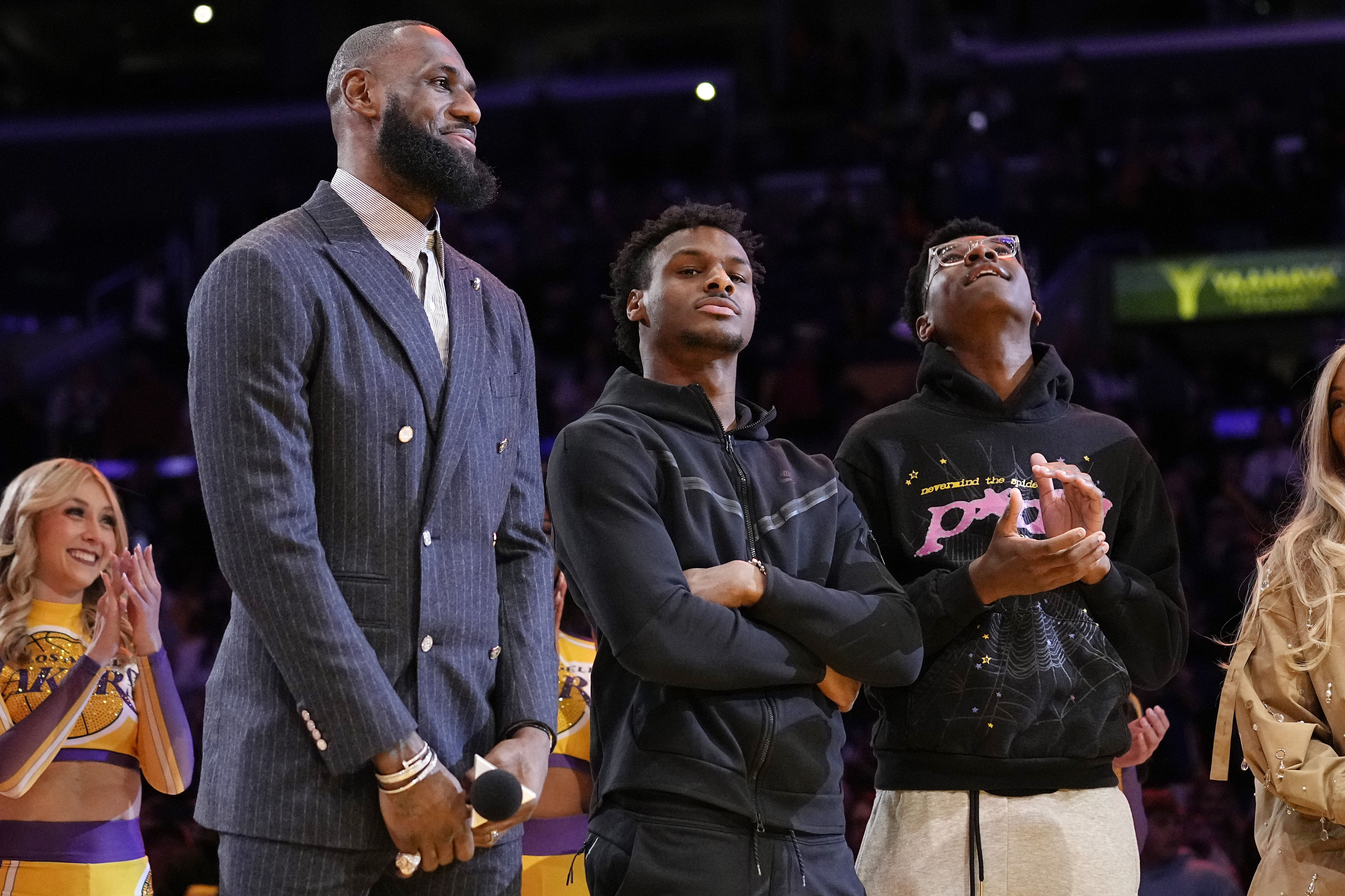 FILE - Los Angeles Lakers forward LeBron James, second from left, Bronny James, center, and Bryce James stand during a ceremony honoring LeBron James as the NBA's all-time leading scorer, before the Lakers' basketball game against the Milwaukee Bucks on Feb. 9, 2023, in Los Angeles. Bronny James was hospitalized in stable condition Tuesday, July 25, 2023, a day after going into cardiac arrest while participating in a practice at the University of Southern California, a family spokesman said. 