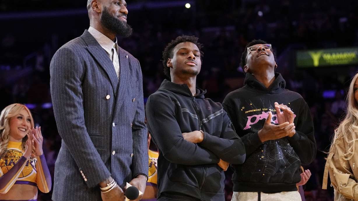 FILE - Los Angeles Lakers forward LeBron James, second from left, Bronny James, center, and Bryce James stand during a ceremony honoring LeBron James as the NBA's all-time leading scorer, before the Lakers' basketball game against the Milwaukee Bucks on Feb. 9, 2023, in Los Angeles. Bronny James was hospitalized in stable condition Tuesday, July 25, 2023, a day after going into cardiac arrest while participating in a practice at the University of Southern California, a family spokesman said.