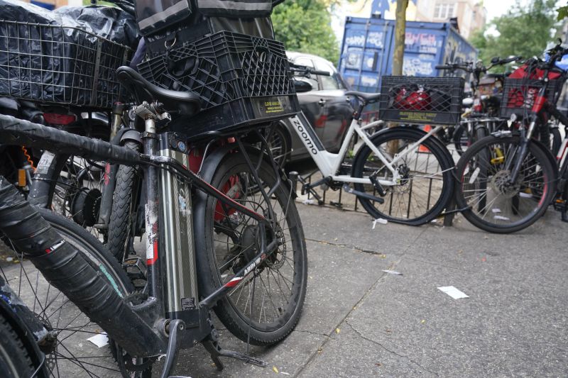Motorized bicycles are parked while delivery workers take a break in New York, Tuesday. As the coronavirus dug in, the number of motorized bicycles dashing through New York City swelled, as cocooning residents grew reliant on food delivery workers for their COVID-era meals. But as the number of e-bikes have grown — now an estimated 65,000 zipping from eateries to doorsteps — so has the frequency of fires and deaths blamed on exploding lithium-ion batteries.