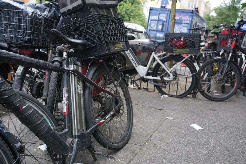 Motorized bicycles are parked while delivery workers take a break in New York, Tuesday. As the coronavirus dug in, the number of motorized bicycles dashing through New York City swelled, as cocooning residents grew reliant on food delivery workers for their COVID-era meals. But as the number of e-bikes have grown — now an estimated 65,000 zipping from eateries to doorsteps — so has the frequency of fires and deaths blamed on exploding lithium-ion batteries.