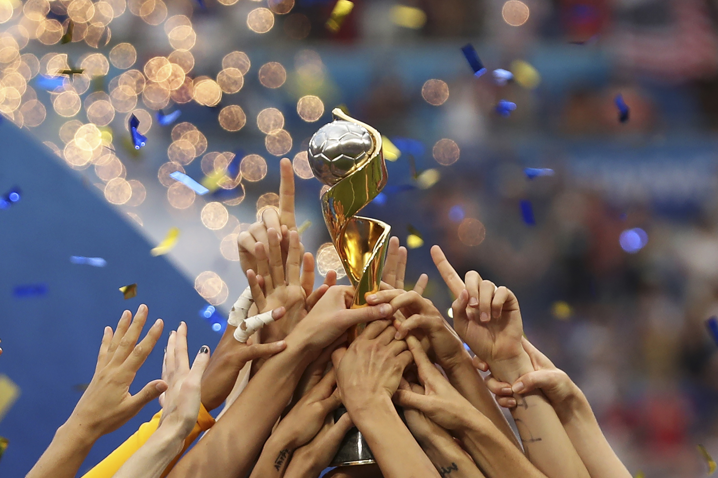 FILE - In this July 7, 2019, file photo, the United States players hold the trophy as they celebrate winning the Women's World Cup final soccer match against The Netherlands at the Stade de Lyon in Decines, outside Lyon, France. The 2023 Women's World Cup will be spread across nine cities in Australia and New Zealand. 