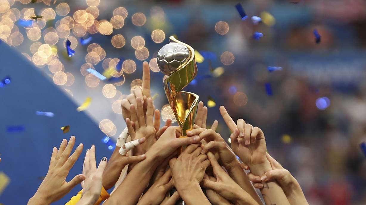 FILE - In this July 7, 2019, file photo, the United States players hold the trophy as they celebrate winning the Women's World Cup final soccer match against The Netherlands at the Stade de Lyon in Decines, outside Lyon, France. The 2023 Women's World Cup will be spread across nine cities in Australia and New Zealand.