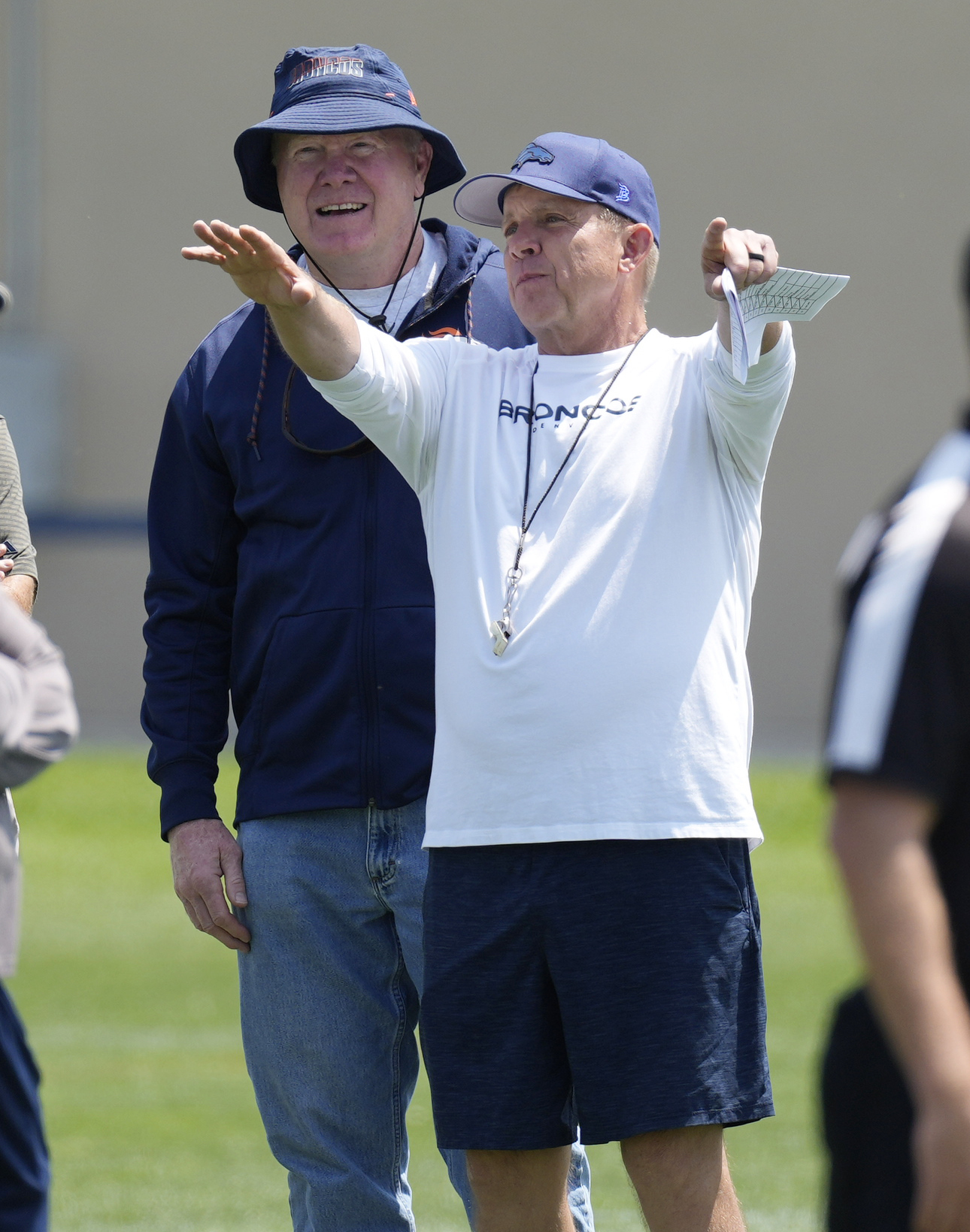 FILE - Denver Broncos head coach Sean Payton, front, chats with retired Broncos linebacker Karl Mecklenburg during NFL football practice, Wednesday, June 14, 2023, in Centennial, Colo. Sean Payton is back on the sideline and this time it's in Denver. The former Saints head coach was hired after spending a year in the broadcast booth. 