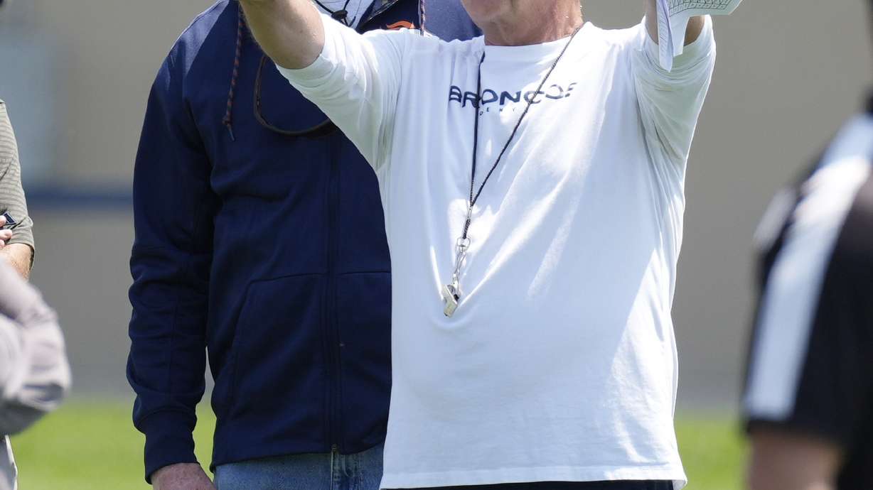 FILE - Denver Broncos head coach Sean Payton, front, chats with retired Broncos linebacker Karl Mecklenburg during NFL football practice, Wednesday, June 14, 2023, in Centennial, Colo. Sean Payton is back on the sideline and this time it's in Denver. The former Saints head coach was hired after spending a year in the broadcast booth.