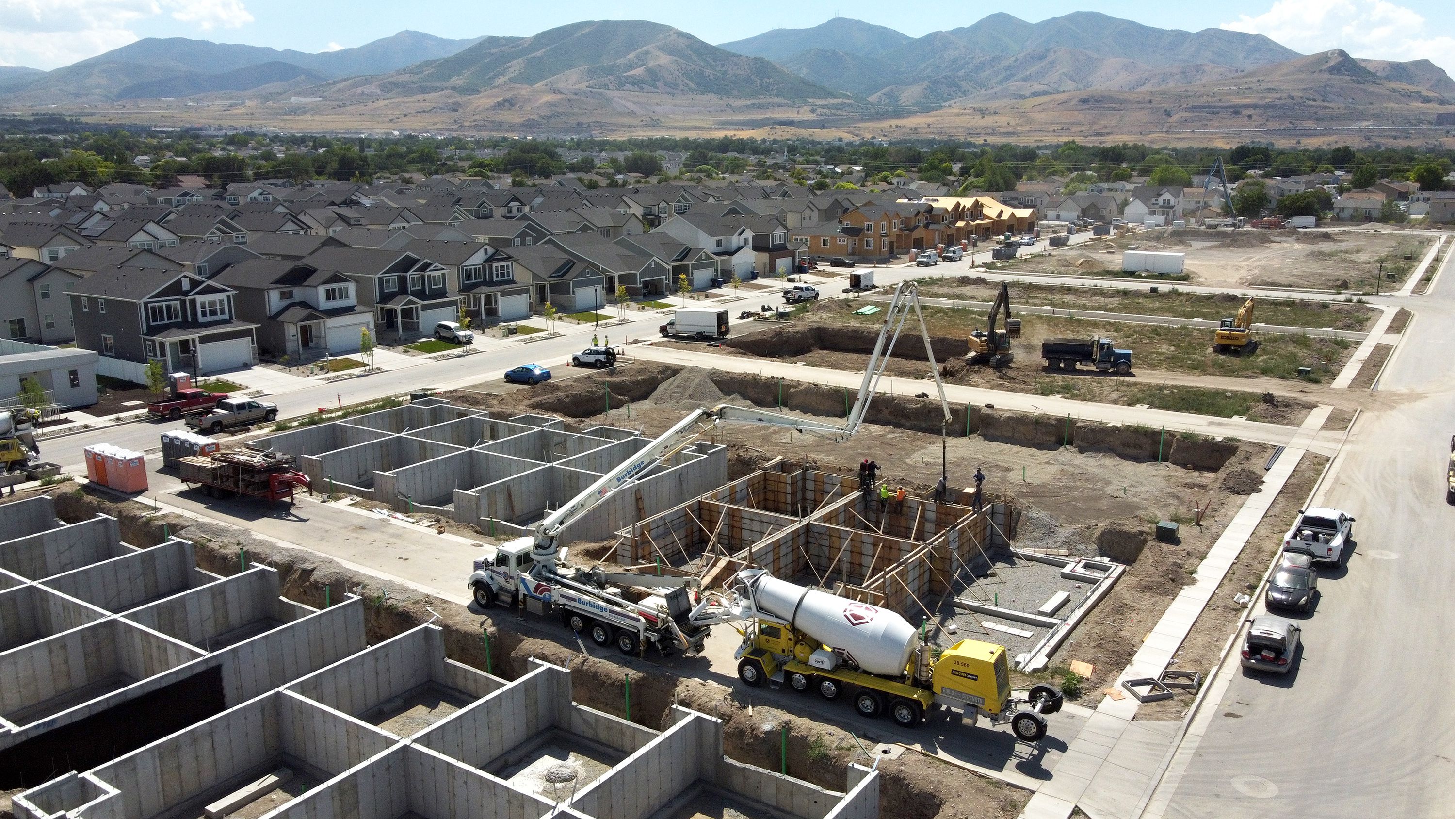 Workers pour concrete at the Ivory Homes Gabler’s Grove development in Magna on Tuesday.