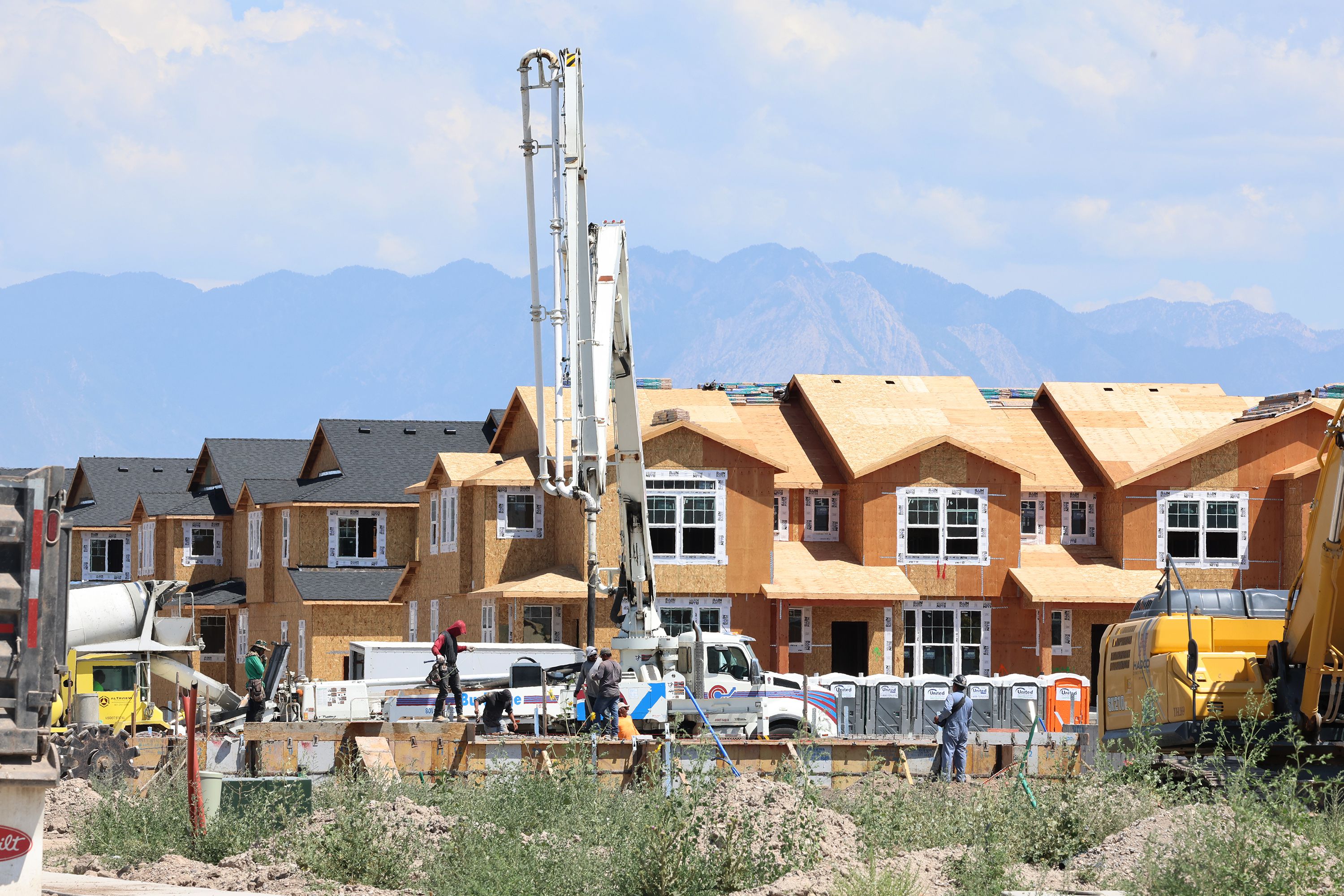 Workers pour concrete at the Ivory Homes Gabler’s Grove development in Magna on Tuesday.
