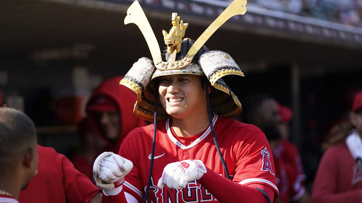 Los Angeles Angels' Shohei Ohtani celebrates wearing a Kabuto samurai warrior helmet after his home run against the Detroit Tigers in the fourth inning during the second baseball game of a doubleheader, Thursday, July 27, 2023, in Detroit.