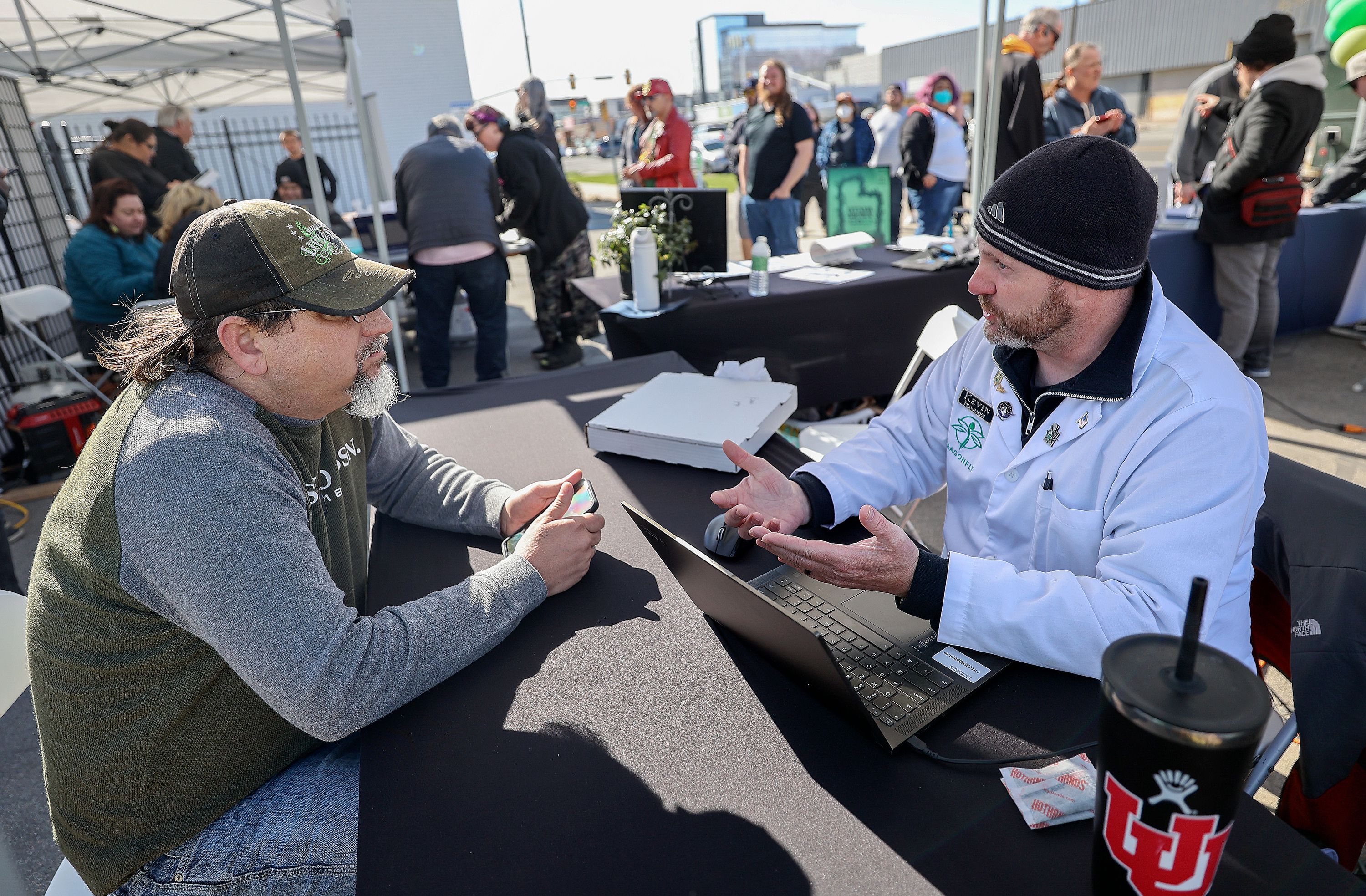 Robert Stosich consults with Dragonfly pharmacist Kevin Baumgartner at Dragonfly Wellness in Salt Lake City on April 20. Stosich hopes to use medical cannabis for anxiety and bipolar disorder. Behind them, people line up to apply for their medical cannabis card. The required visit with a qualified medical provider, which can cost hundreds of dollars and is not covered by insurance, was offered at a deep discount during the Utah Grown event.