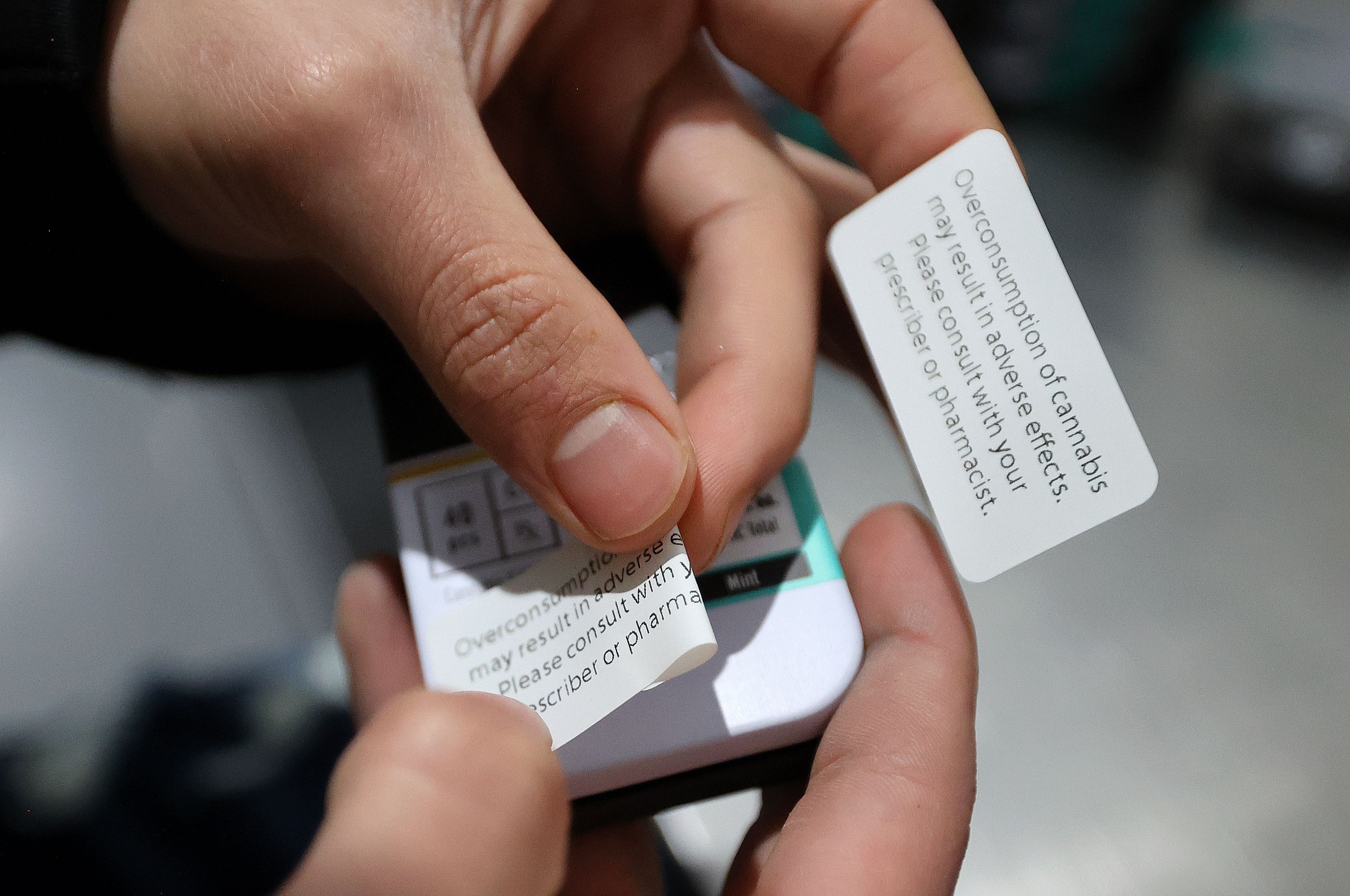 Gabe Flores, Dragonfly quality control agent, puts stickers on cannabis packaging at the Dragonfly processing plant in South Salt Lake on March 24. Stickers are needed to adhere to rapidly changing rules and regulations for cannabis packaging.