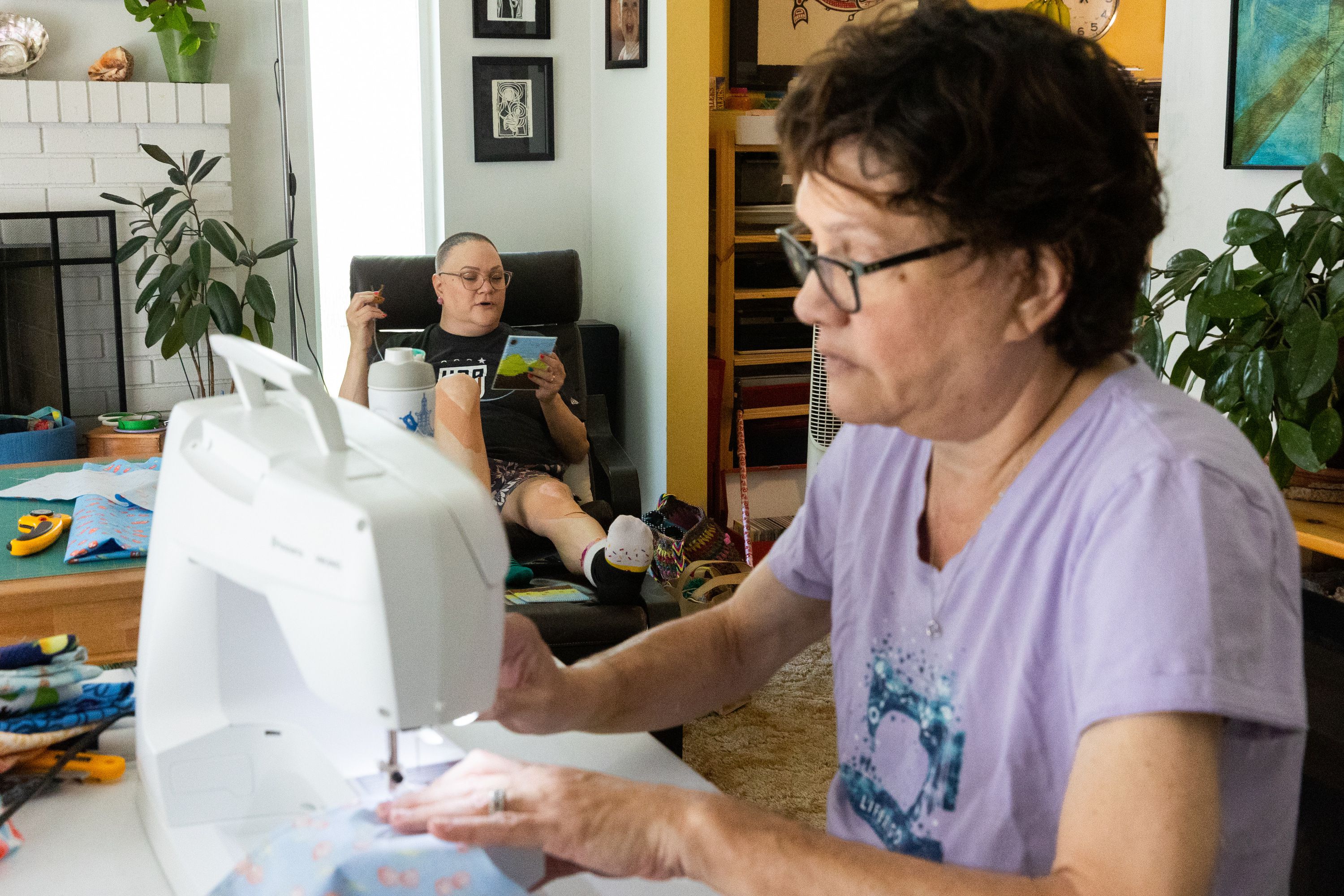 Sisters Brooke Moffat, left, and Cami Munk, together called the “Stitching Sisters,” work on projects at Munk’s home in Murray on Saturday.