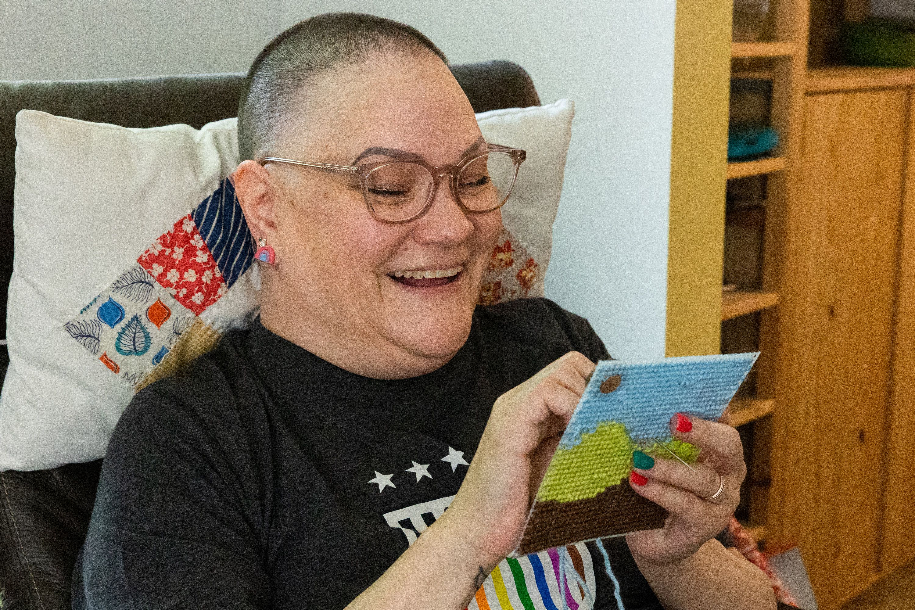 Brooke Moffat, one the “Stitching Sisters,” works on a cross stitch at her sister Cami Munk’s home in Murray on Saturday, July 22, 2023.