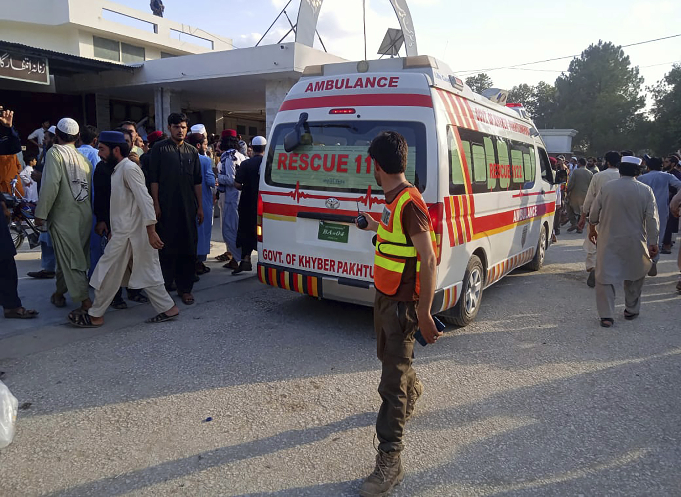 In this photo provided by Rescue 1122 Head Quarters, an ambulance carries injured people after a bomb explosion in the Bajur district of Khyber Pakhtunkhwa, Pakistan, Sunday. 