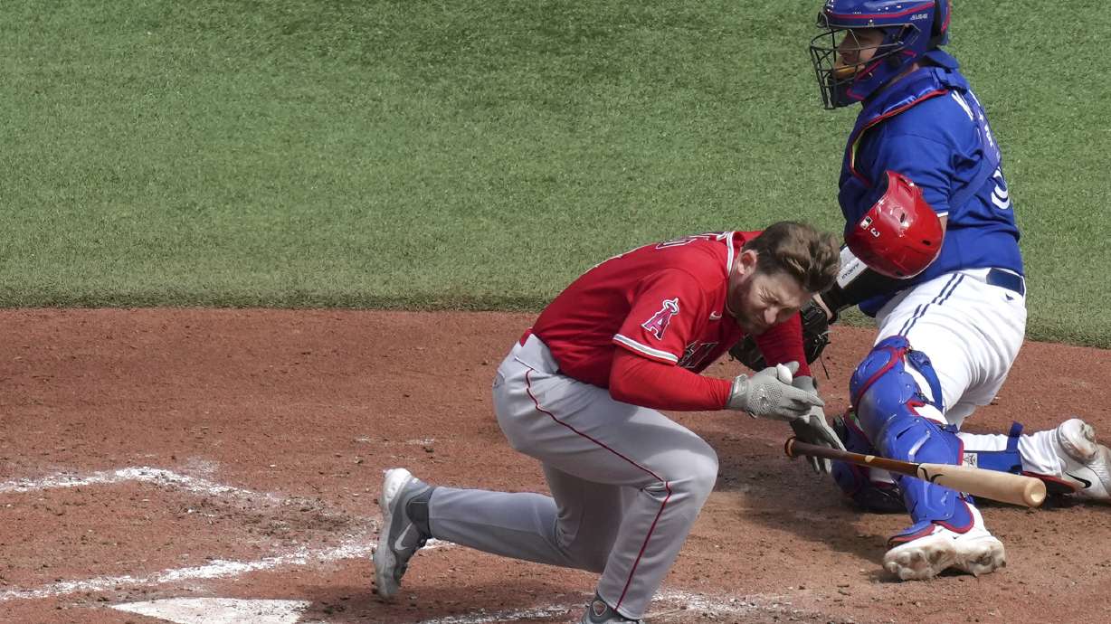 Los Angeles Angels' Taylor Ward reacts after being hit by a pitch from Toronto Blue Jays' Alek Manoah, as Blue Jays catcher Alejandro Kirk looks on during the fifth inning of a baseball game in Toronto, Saturday, July 29, 2023.