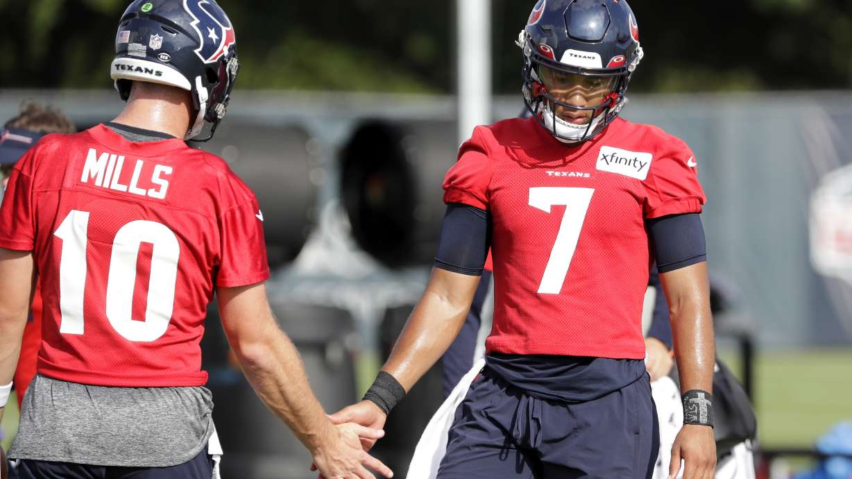 Houston Texans quarterbacks Davis Mills (10) and C.J. Stroud (7) low five during the NFL football team's training camp, Sunday, July 30, 2023, in Houston.