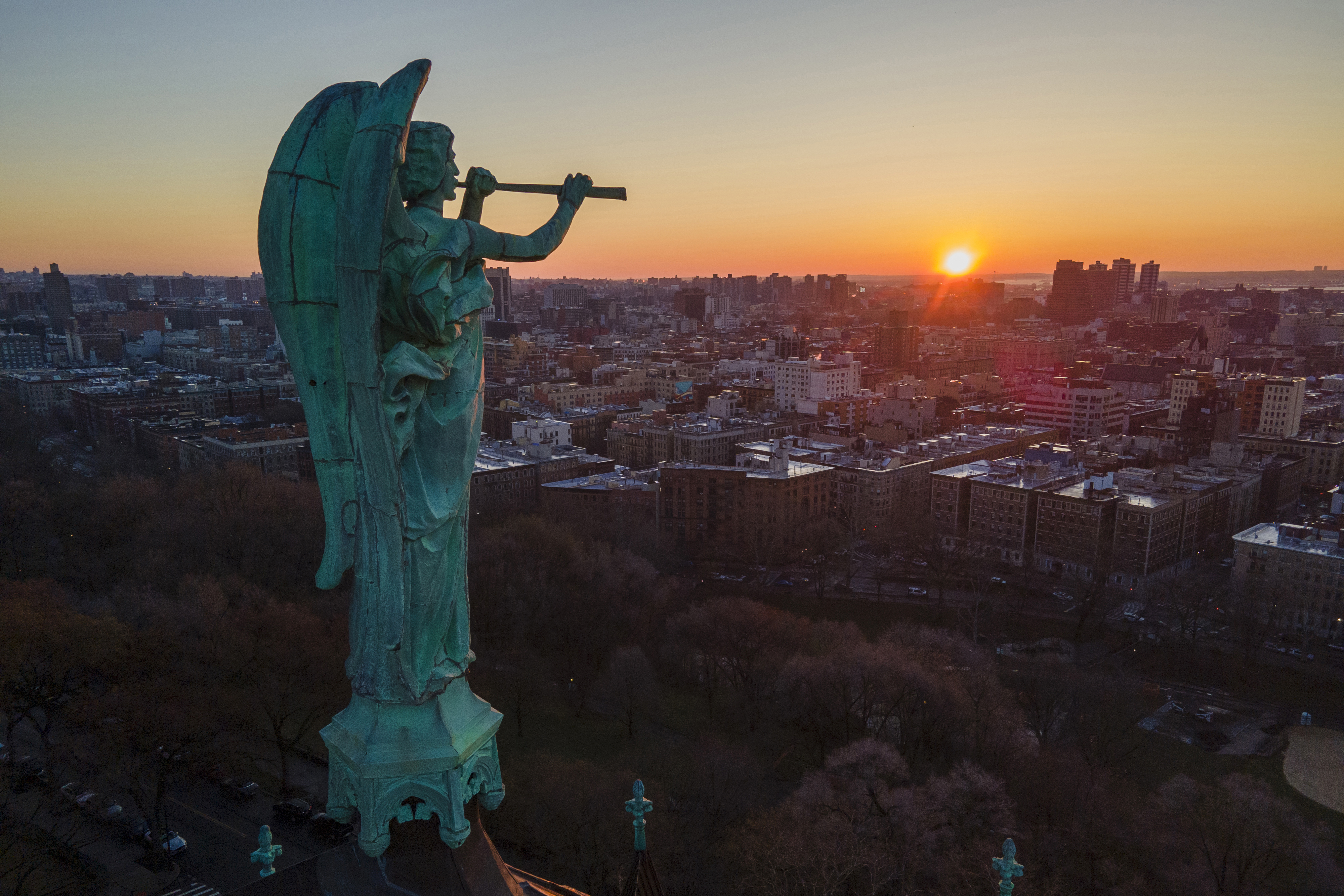 A bronze statue of the Archangel Gabriel blowing a trumpet stands at the Cathedral of St. John the Divine as the sun rises in the Morningside Heights neighborhood of the borough of Manhattan in New York on March 26.