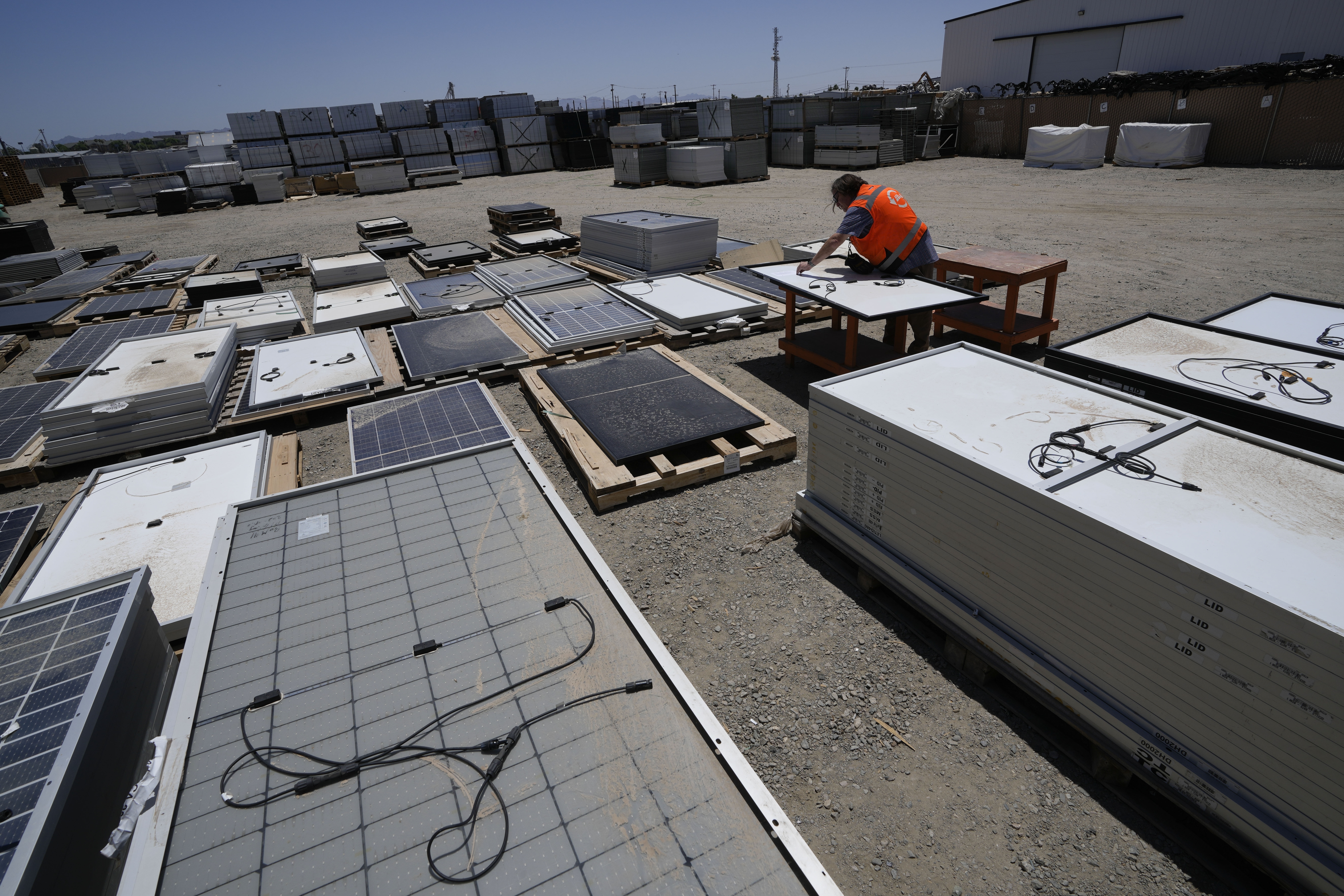 Dwight Clark inspects a used solar panel at We Recycle Solar on June 6, in Yuma, Ariz. North America’s first utility-scale solar panel recycling plant opened to address what founders of the company call a “tsunami” of solar waste.
