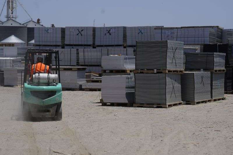 A worker drives a fork lift near rows of used solar panels as they begin the recycling process at We Recycle Solar on June 6 in Yuma, Ariz. North America’s first utility-scale solar panel recycling plant opened to address what founders of the company call a “tsunami” of solar waste, as technology that became popular in the early 2000s rapidly scales up.