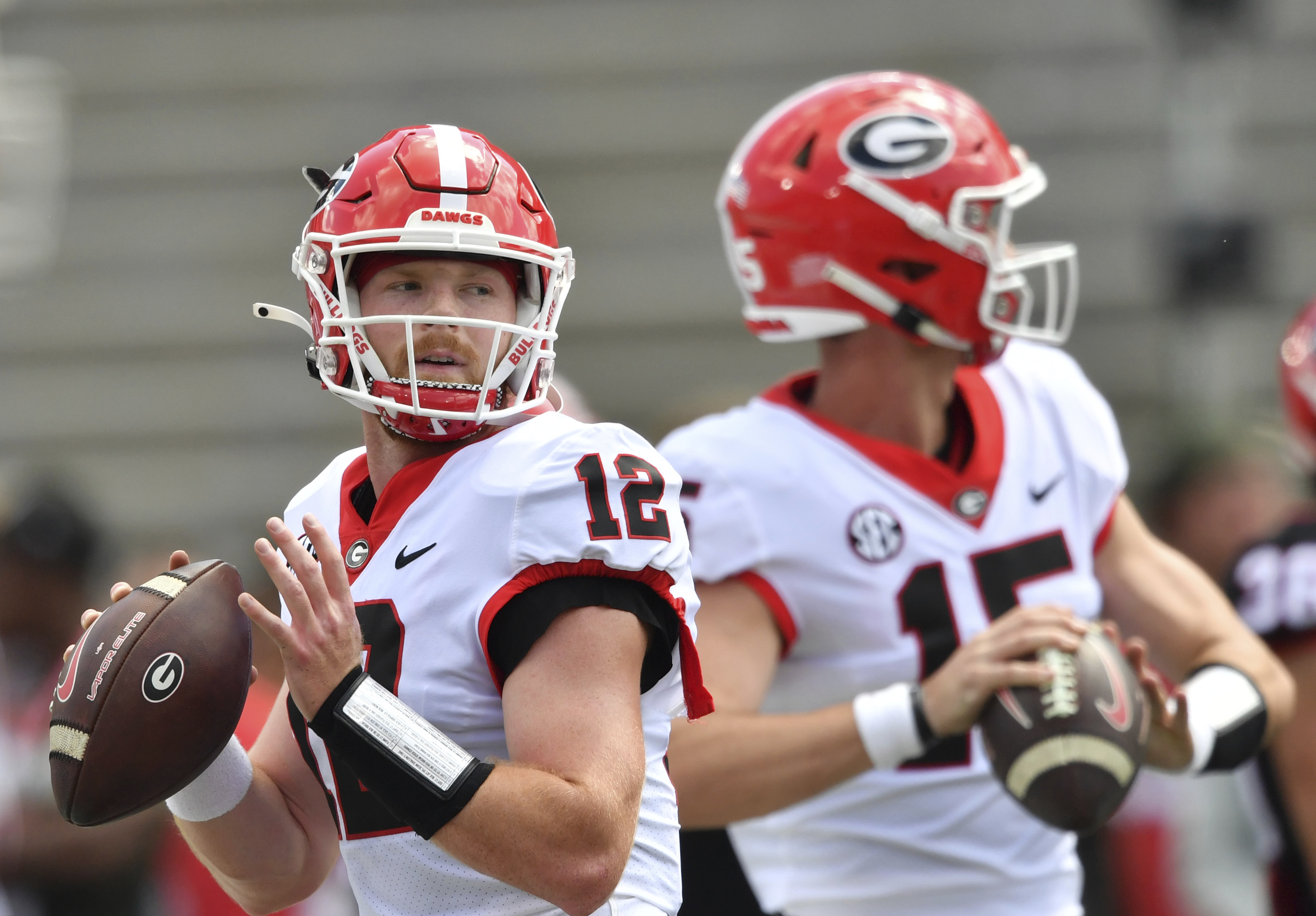FILE - Georgia quarterbacks Brock Vandagriff (12) and Carson Beck (15) warm up before the G - Day spring football game at Sanford Stadium, Saturday, April 15, 2023, in Athens, Ga. Beck has attempted 58 passes over the past three seasons. Third-year player Brock Vandagriff was a five-star recruit. 