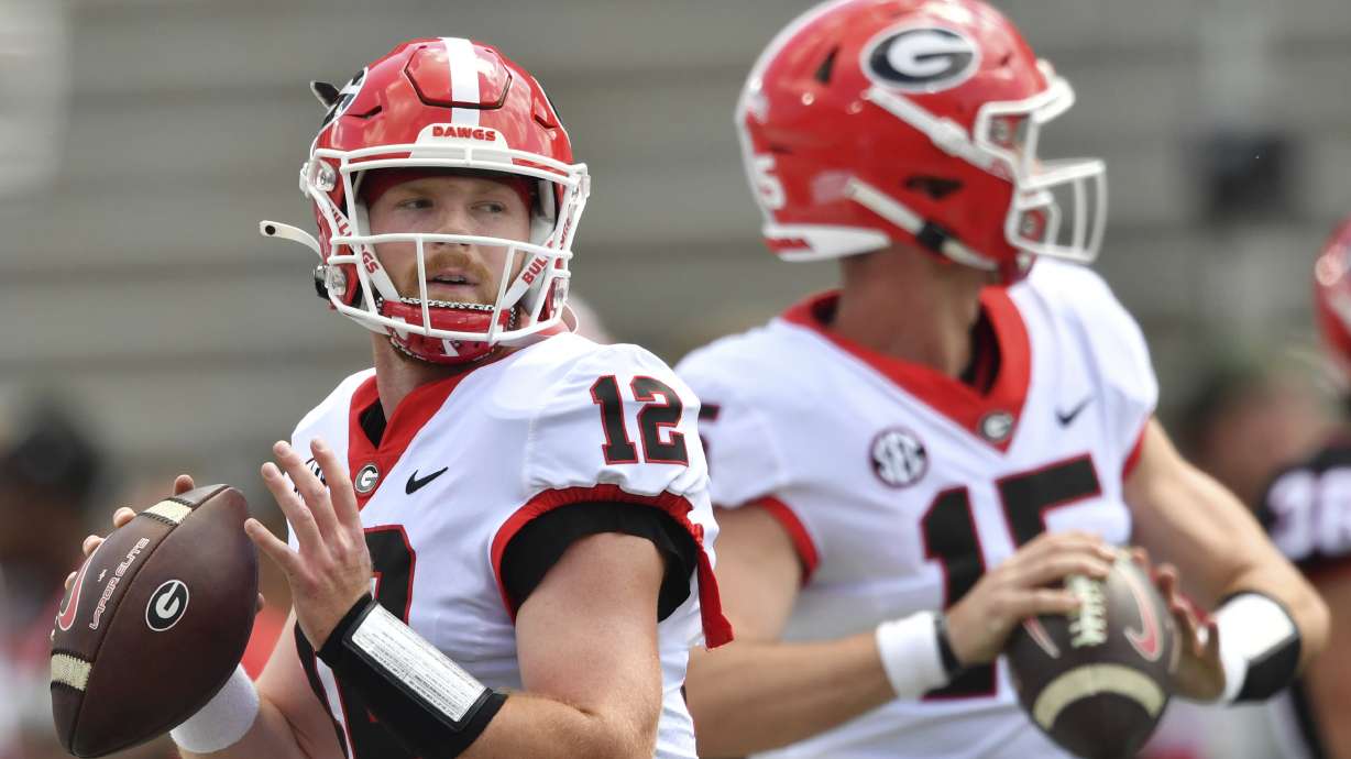 FILE - Georgia quarterbacks Brock Vandagriff (12) and Carson Beck (15) warm up before the G - Day spring football game at Sanford Stadium, Saturday, April 15, 2023, in Athens, Ga. Beck has attempted 58 passes over the past three seasons. Third-year player Brock Vandagriff was a five-star recruit.