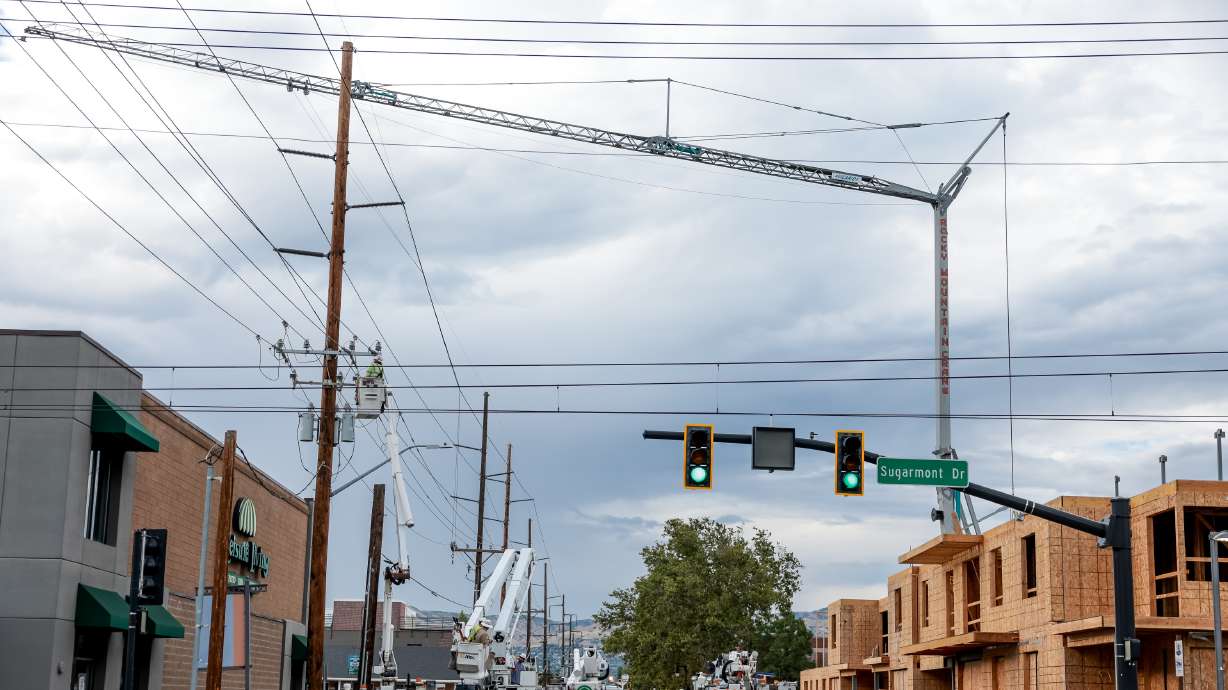 Rocky Mountain Power and emergency crews respond after a wire from a construction crane hit power lines on 900 East near 2100 South in Salt Lake City on Tuesday.