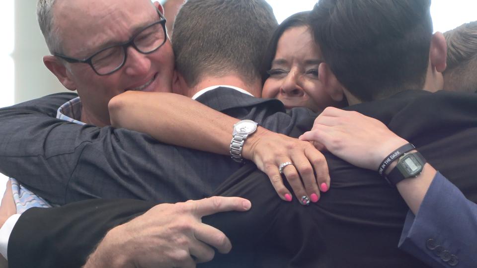 Family embraces as triplets return on the same day Tuesday at Salt Lake City International Airport after the trio served missions for The Church of Jesus Christ of Latter-day Saints.