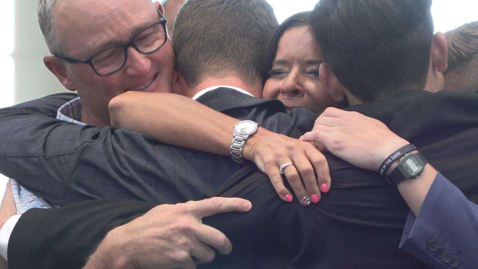 Family embraces as triplets return on the same day Tuesday at Salt Lake City International Airport after the trio served missions for The Church of Jesus Christ of Latter-day Saints.