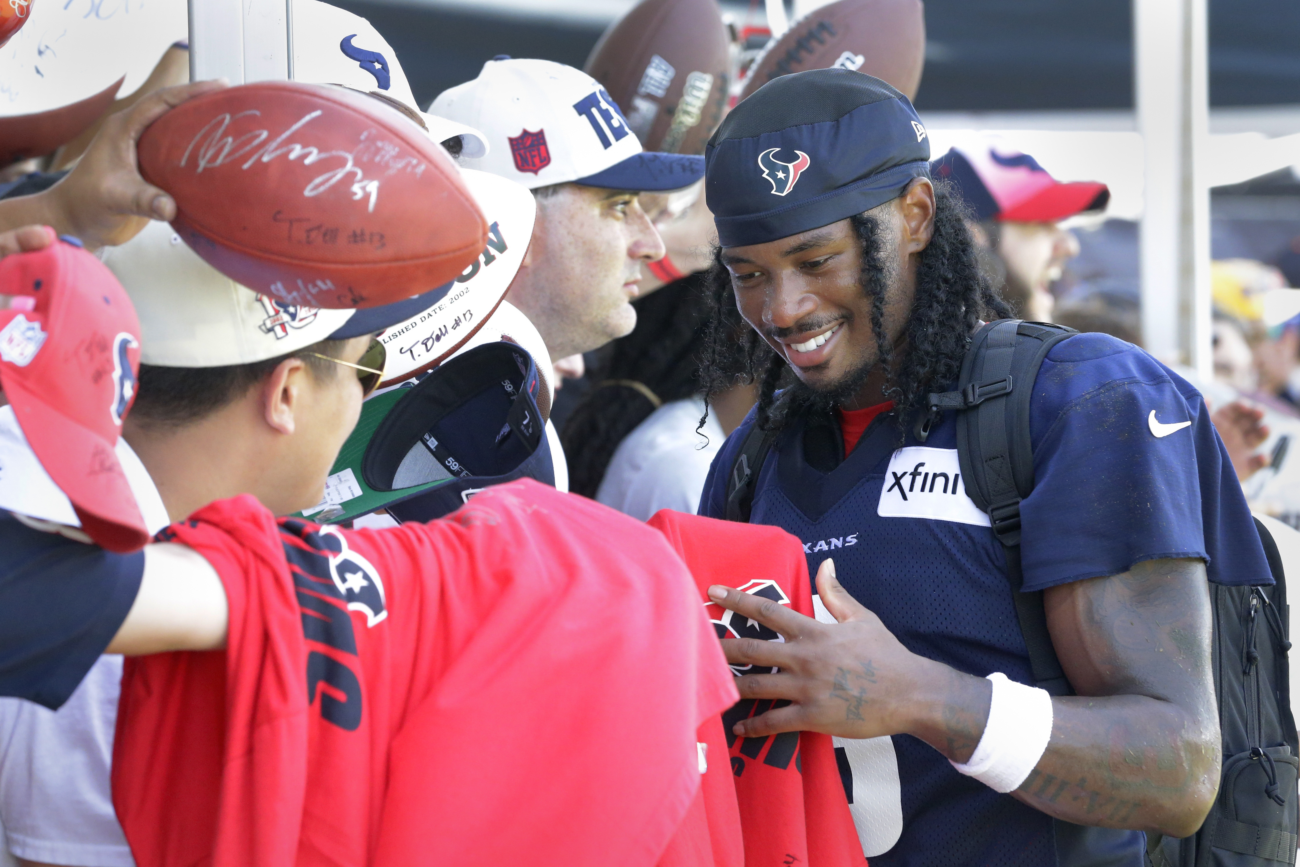 Houston Texans wide receiver John Metchie III gives autographs to fans after the NFL football team's training camp Sunday, July 30, 2023, in Houston.