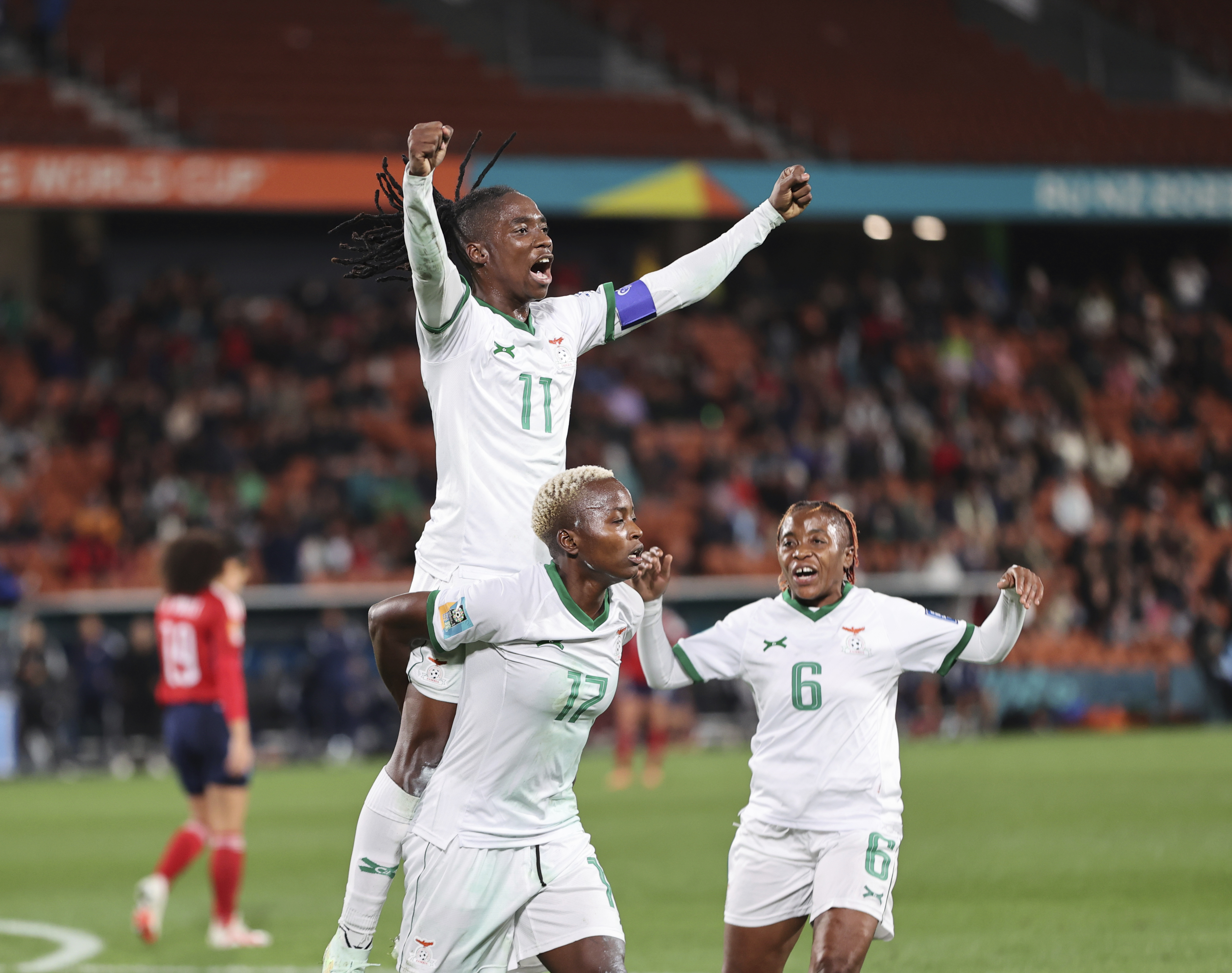 FILE - Zambia's Racheal Kundananji, bottom, carries teammate Barbra Banda as the celebrate the final goal of the match with Zambia's Mary Wilombe, right, during the Women's World Cup Group C soccer match between Costa Rica and Zambia in Hamilton, New Zealand, Monday, July 31, 2023. The group stage was the source of enormous national pride for Portugal, the Philippines, Vietnam, Panama, Ireland, Haiti, Zambia and Morocco, all newcomers to the highest level of international women's soccer.